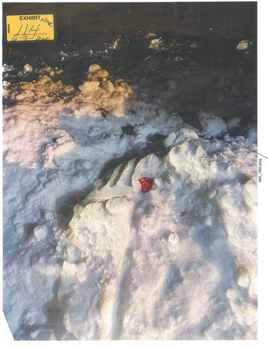 A red object in disturbed snow at night, with 2024 exhibit sticker 114.