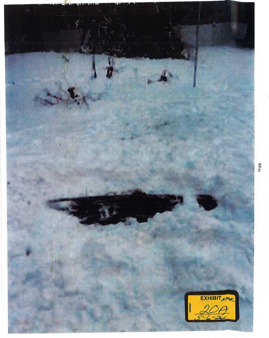 Disturbed snow around an exposed dark patch of ground, with an exhibit 20A sticker.