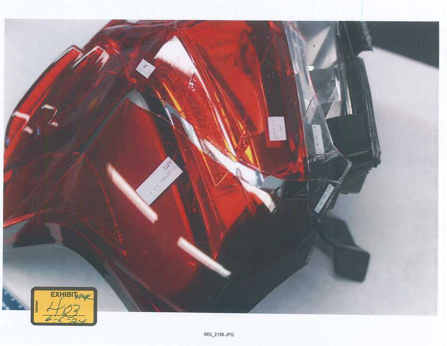Red and clear lens sections with small labels arranged on a taillight housing; 2024 exhibit sticker 403.