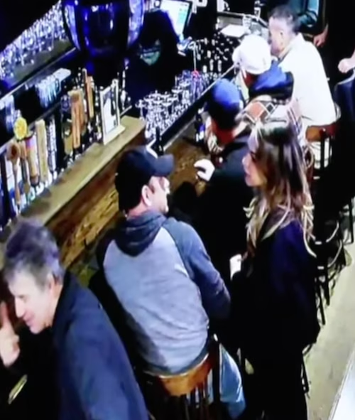 Elevated view of patrons beside a bar, with taps, glassware and stools visible.